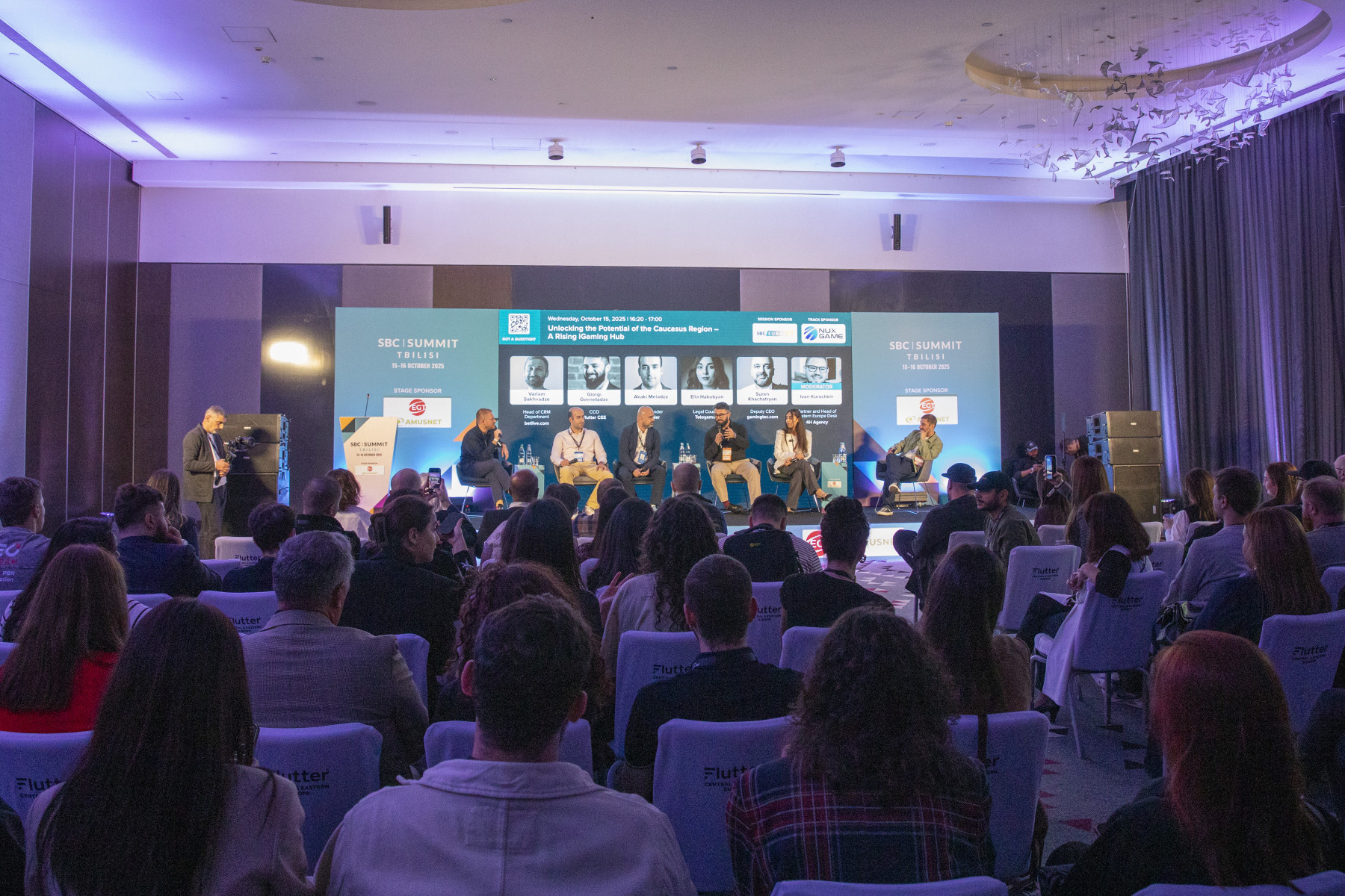 Panel discussion at SBC Summit Tbilisi with speakers on stage addressing a large audience